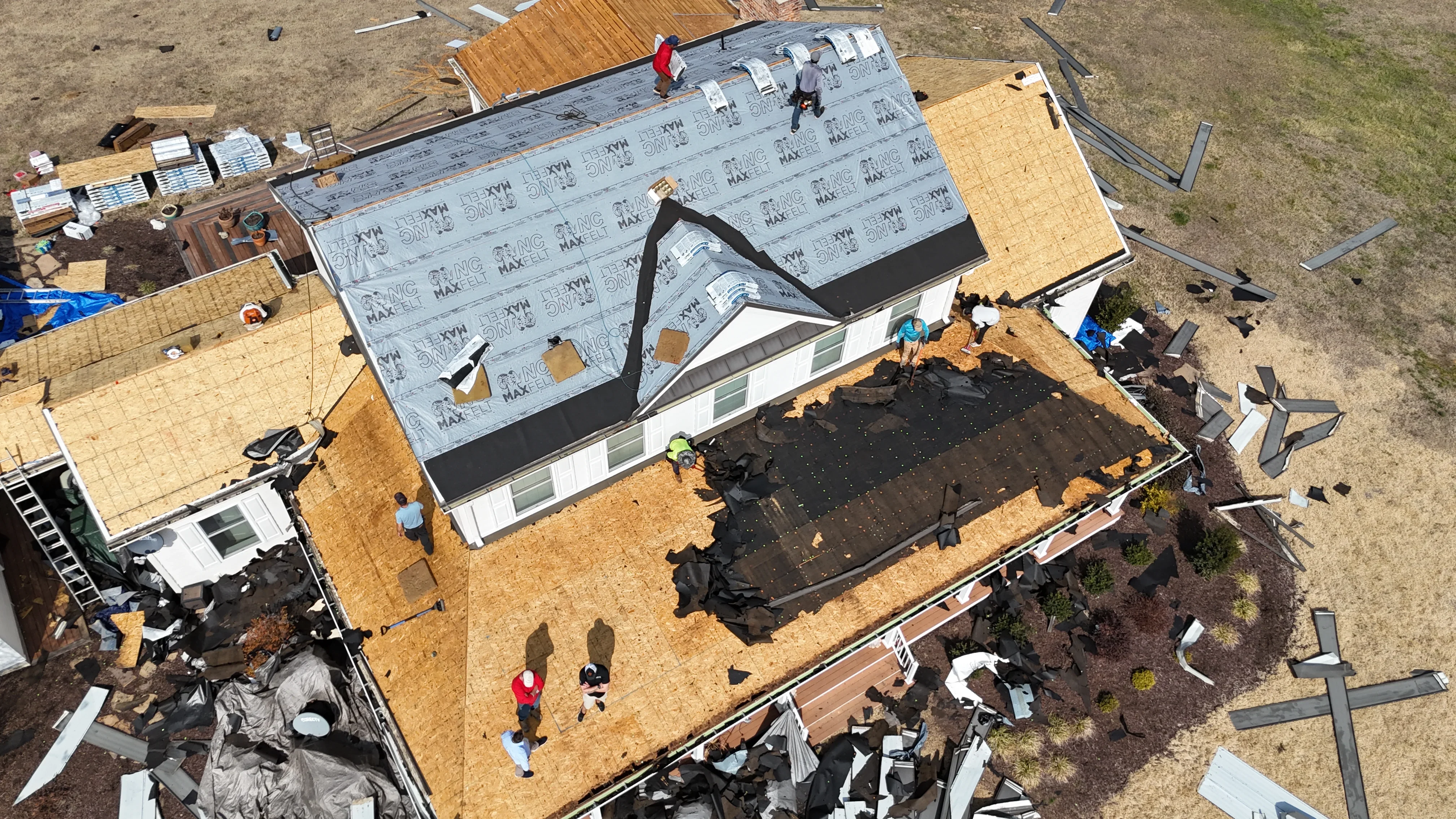 Aerial view of roof replacement with synthetic underlayment and OSB sheathing installation