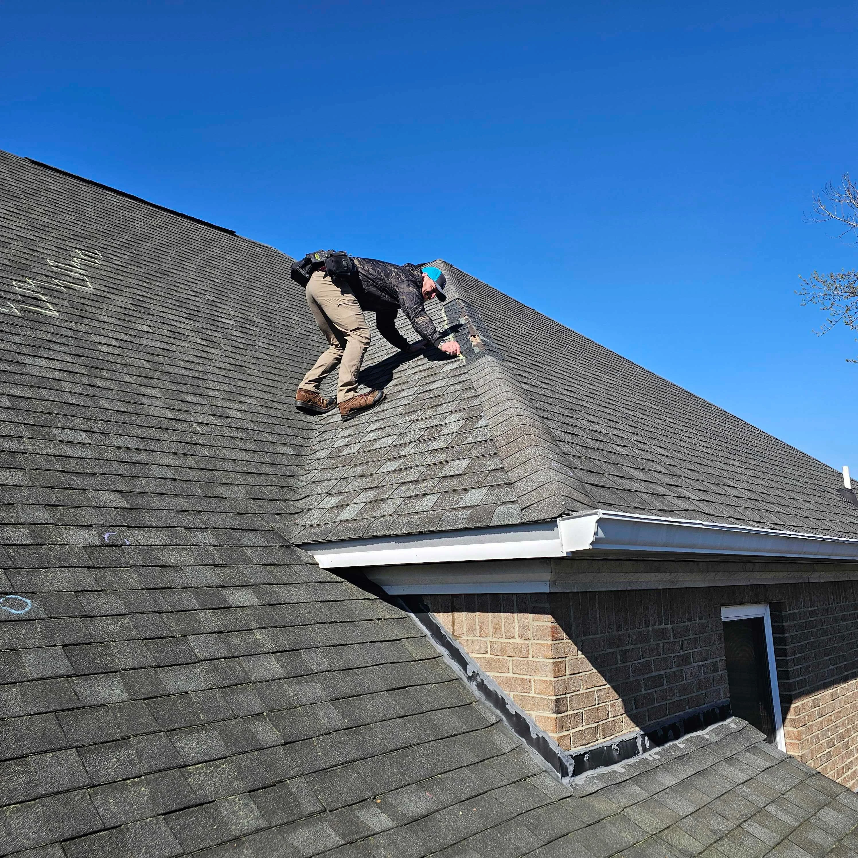 A roofing contractor repairing damaged shingles and flashing on a brick ranch home in Cayce, SC. Close-up view shows replaced shingle sections and sealed flashing along the roofline.